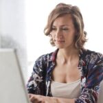 Engineering - Woman in Blue Floral Top Sitting While Using Laptop