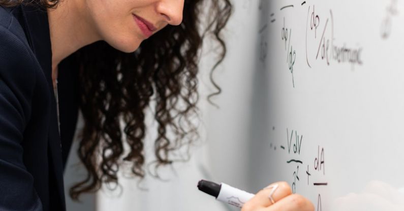 Quantum Physics - Woman Writing Formula on Whiteboard