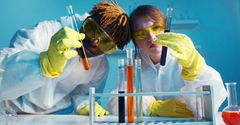 Microscopy - A Man and a Woman Holding a Test Tube