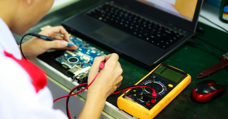 Electronics - Man Soldering a Circuit Board